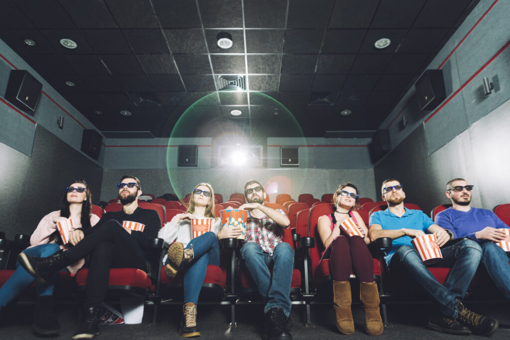 People watching a movie with 3D glasses and popcorn in a premium theater