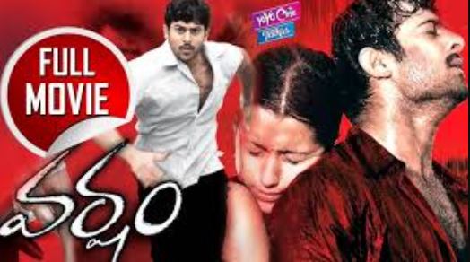 Crowd enjoying the screening of Varsham starring Prabhas at a movie theater with a lively atmosphere.