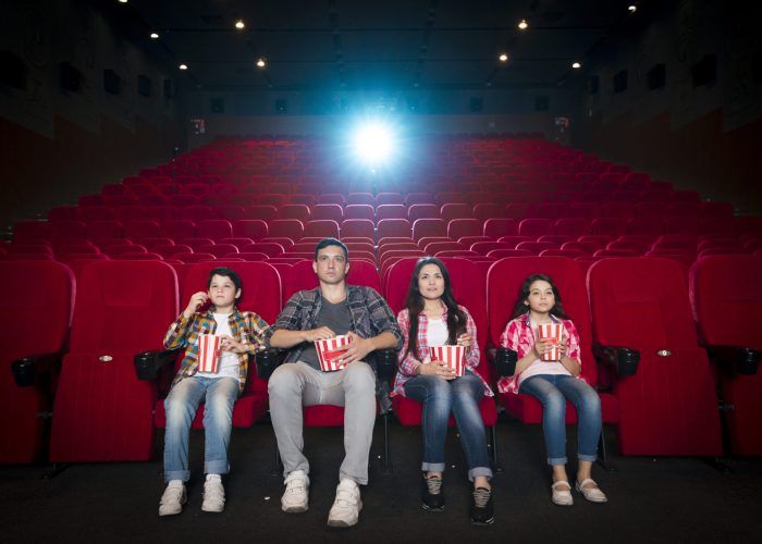 Family enjoying a film in the best movie theater with popcorn